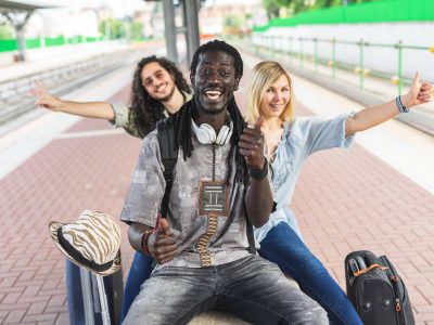 Group of multiracial friends waiting train at station rail as they prepare to embarking on a vacation together.
